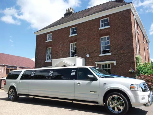 White stretch limousine outside a country house, ready for a prom arrival