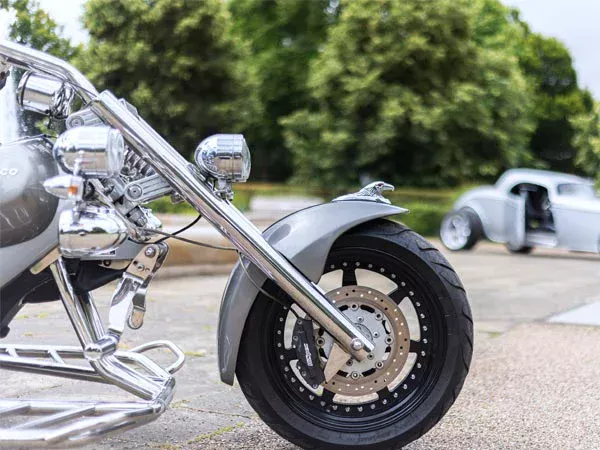 Close-up of the Rewaco trike chrome front fork, headlights and alloy wheel