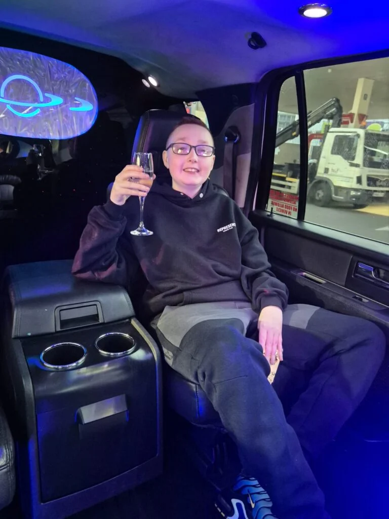 Young guest raising a glass in the back of a Starlite limousine