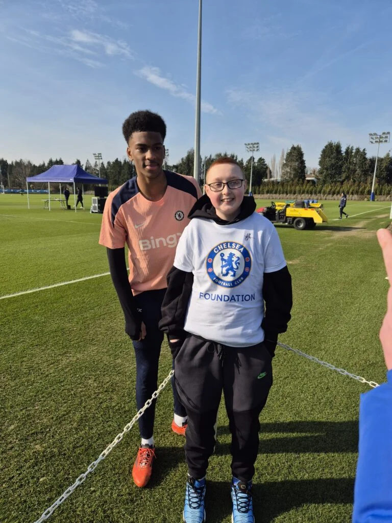 Young fan photographed with a player at the Chelsea training ground