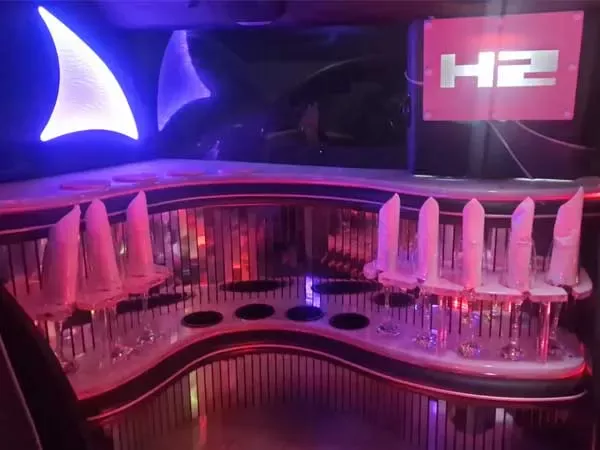 The illuminated bar inside the pink Hummer, with the backlit H2 sign above it